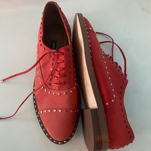 Orange studded Nine West Oxford flat shoes.